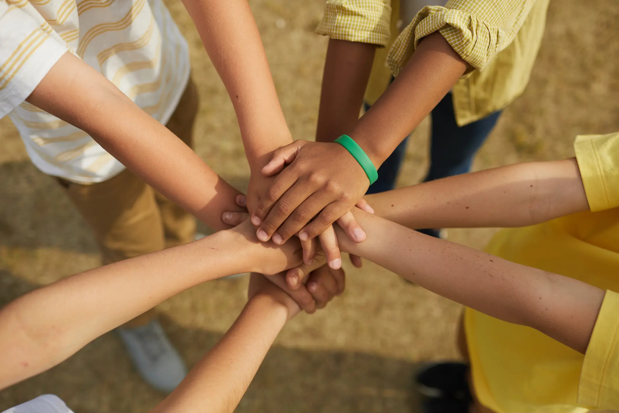 Multiple hands stacked together symbolizing unity and teamwork.
